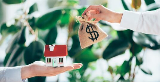 cropped shot of people exchanging sackcloth bag with dollar sign and house model